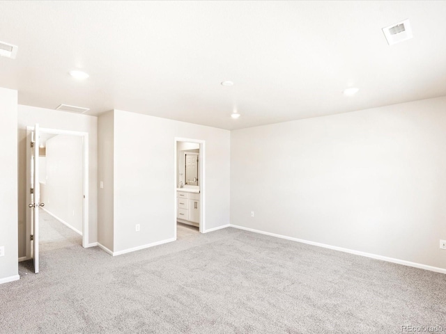 spare room featuring baseboards, light carpet, and visible vents