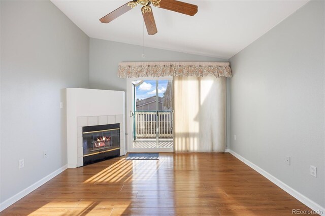 3857 Mossy Rock Dr Unit 201, Highlands Ranch, CO 80126 - unfurnished living room with vaulted ceiling, a tiled fireplace, wood finished floors, and ceiling fan