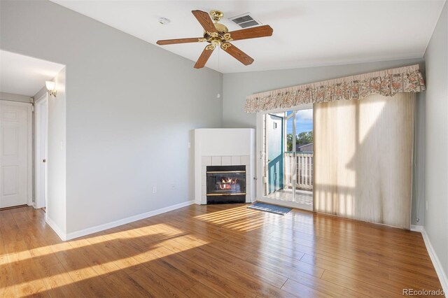 3857 Mossy Rock Dr Unit 201, Highlands Ranch, CO 80126 - unfurnished living room featuring vaulted ceiling, a tile fireplace, wood finished floors, and ceiling fan
