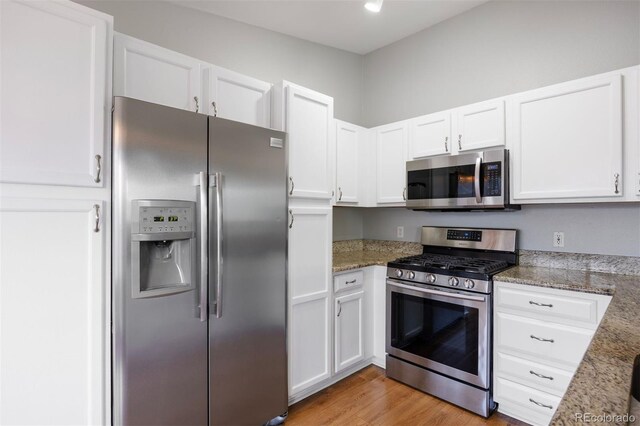 3857 Mossy Rock Dr Unit 201, Highlands Ranch, CO 80126 - kitchen featuring stainless steel appliances, white cabinets, and light wood-type flooring