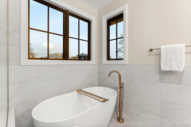 bathroom featuring tile walls and a bathtub