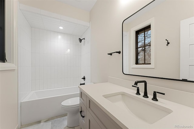 full bathroom featuring tiled shower / bath combo, vanity, and toilet