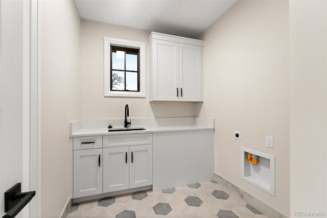 laundry room featuring electric dryer hookup, sink, and cabinets