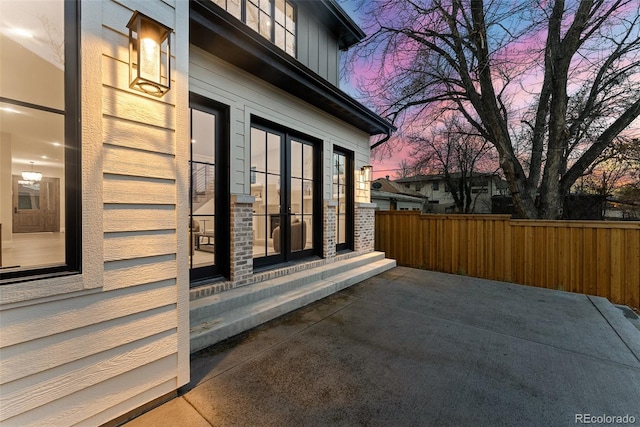 property exterior at dusk with a patio area