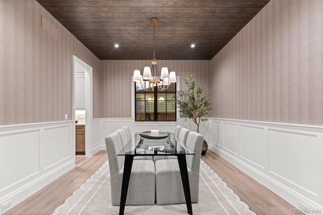 dining room with light wood-style floors, wainscoting, and wallpapered walls