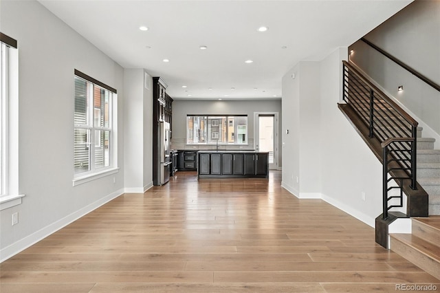 815 Promenade Dr, Superior, CO 80027 - unfurnished living room with light wood-style flooring, stairway, baseboards, and recessed lighting