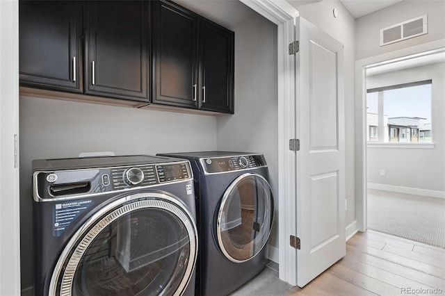 815 Promenade Dr, Superior, CO 80027 - laundry area with cabinet space, washer and clothes dryer, baseboards, and light wood-type flooring