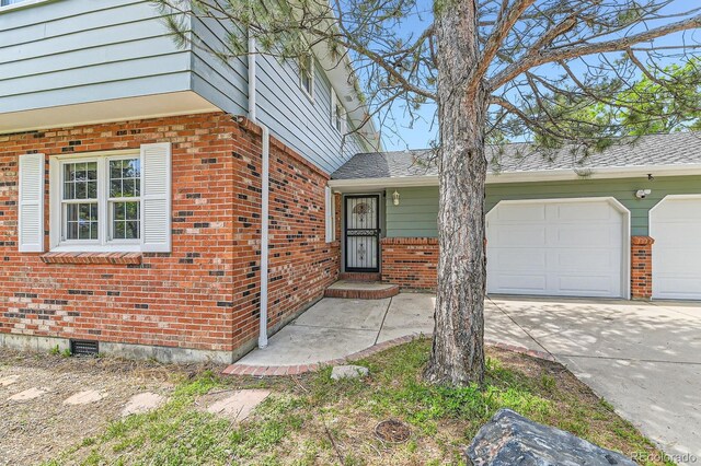 6351 S Andes Pl, Centennial, CO 80016 - view of exterior entry with brick siding, concrete driveway, and a garage