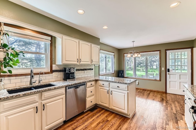 6351 S Andes Pl, Centennial, CO 80016 - kitchen featuring stainless steel dishwasher, a sink, decorative backsplash, light wood-type flooring, and recessed lighting