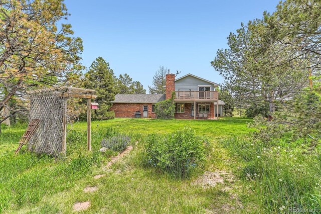 6351 S Andes Pl, Centennial, CO 80016 - rear view of property with a chimney, brick siding, a wooden deck, and a lawn