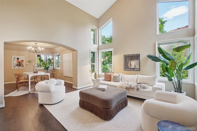 2841 Wyecliff Way, Highlands Ranch, CO 80126 - living area with arched walkways, dark wood finished floors, high vaulted ceiling, and a chandelier