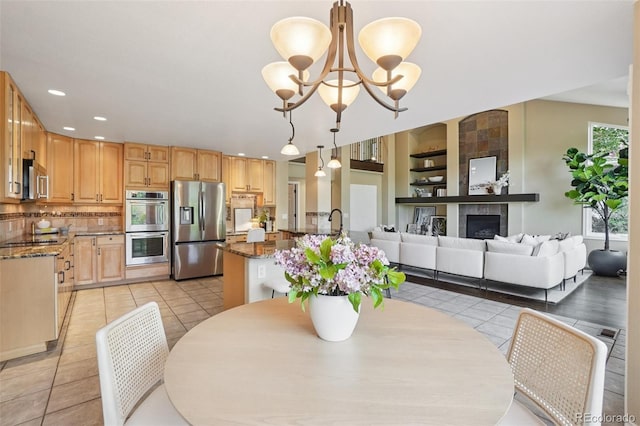 2841 Wyecliff Way, Highlands Ranch, CO 80126 - dining room with light tile patterned floors, a chandelier, a tile fireplace, recessed lighting, and built in features