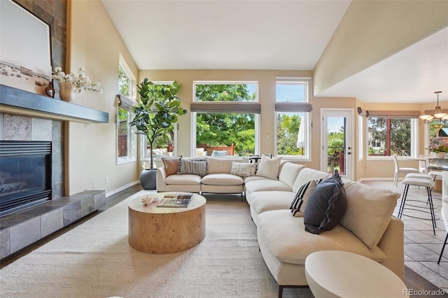 2841 Wyecliff Way, Highlands Ranch, CO 80126 - living area featuring a tiled fireplace, vaulted ceiling, and a chandelier