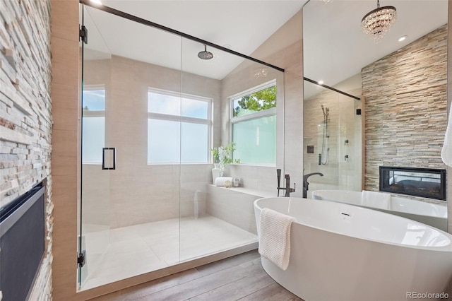 2841 Wyecliff Way, Highlands Ranch, CO 80126 - full bathroom with a fireplace, lofted ceiling, a shower stall, a soaking tub, and wood finished floors