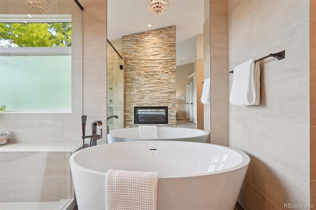 2841 Wyecliff Way, Highlands Ranch, CO 80126 - bathroom with a freestanding tub, a fireplace, a tile shower, and tile walls