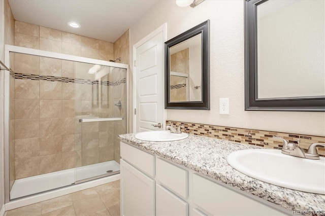 full bathroom with a stall shower, tasteful backsplash, and a sink