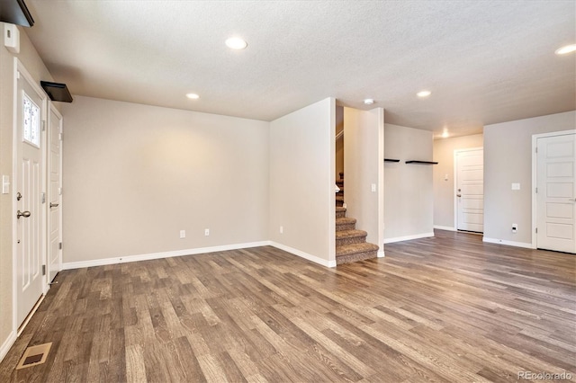 basement featuring stairs, visible vents, baseboards, and wood finished floors