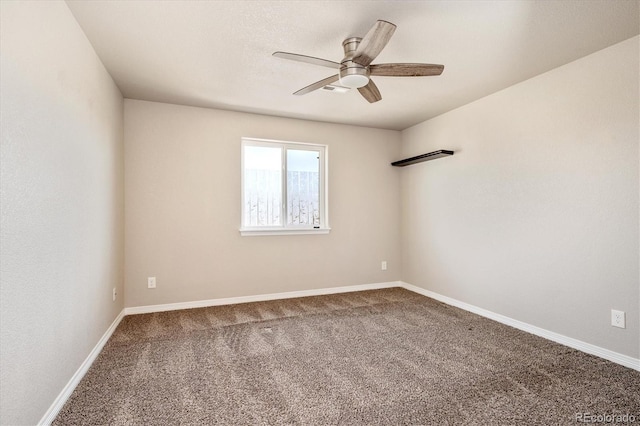 carpeted empty room featuring baseboards and a ceiling fan