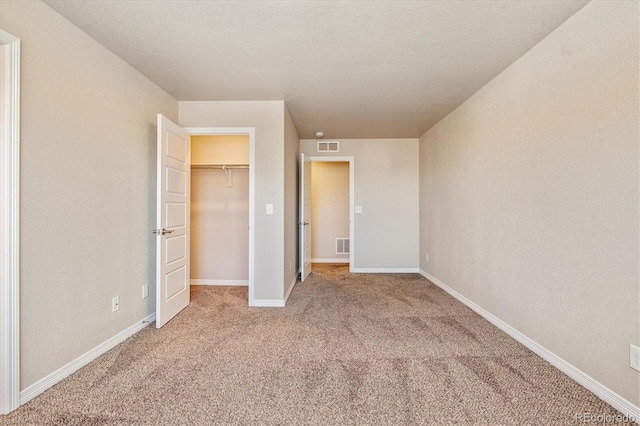 unfurnished bedroom with carpet floors, visible vents, and baseboards