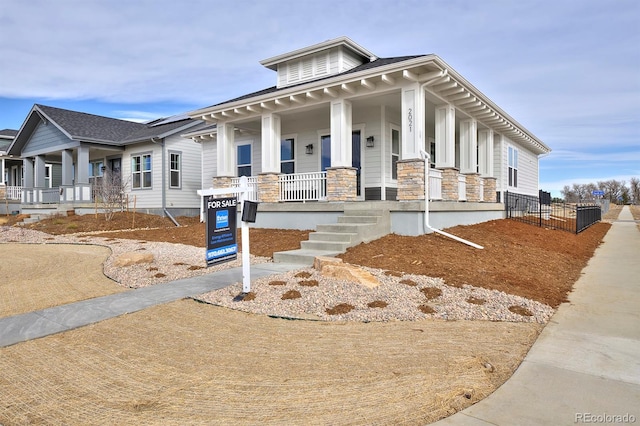 view of front of house with stone siding and covered porch