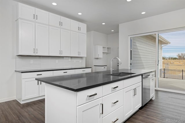 kitchen featuring dark countertops, tasteful backsplash, dark wood-style flooring, and a sink