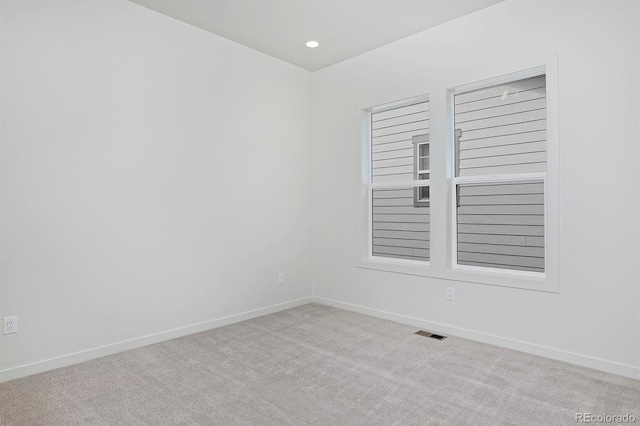 carpeted empty room featuring recessed lighting, visible vents, and baseboards