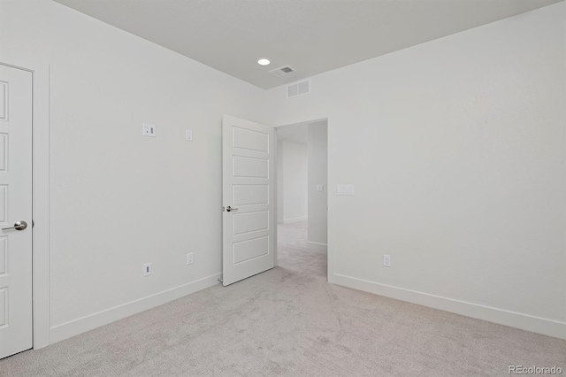 carpeted empty room with visible vents and baseboards