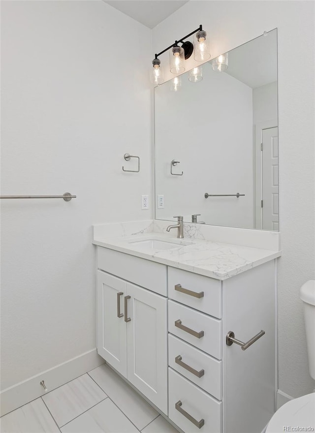 bathroom featuring vanity, toilet, and baseboards