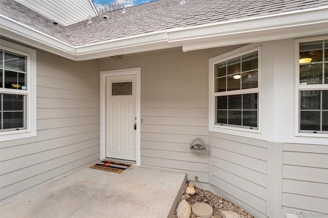property entrance featuring a shingled roof