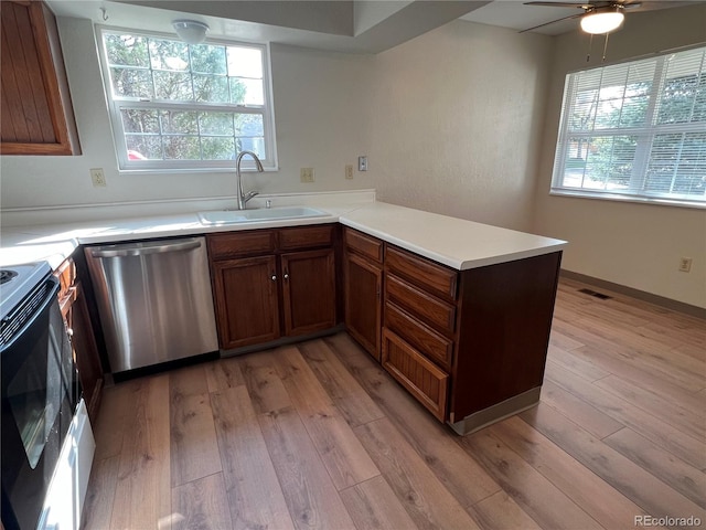 kitchen featuring dishwasher, a sink, electric stove, a peninsula, and light wood-style flooring