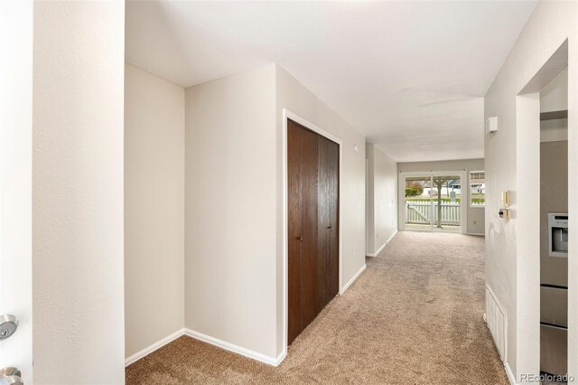 corridor featuring carpet floors and baseboards