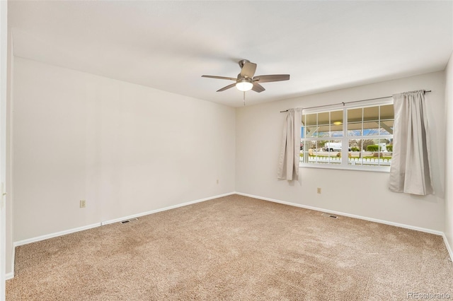 unfurnished room with a ceiling fan, carpet, and baseboards