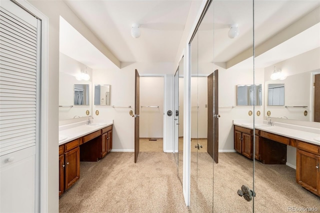 full bath featuring a closet, vanity, baseboards, and carpet floors