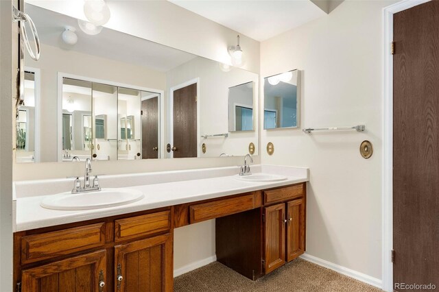 full bath with double vanity and baseboards