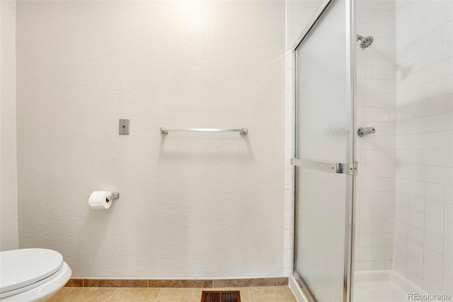 full bathroom featuring a stall shower and toilet