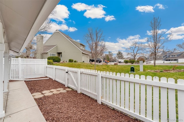 fenced yard with a residential view