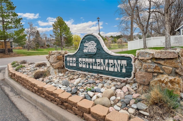 community / neighborhood sign with fence