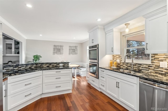 kitchen featuring white cabinetry, stainless steel appliances, sink, and dark stone counters