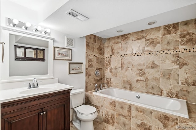 full bathroom featuring tiled shower / bath, vanity, and toilet