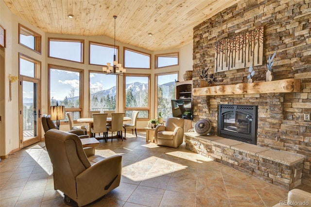 tiled living room with high vaulted ceiling, a mountain view, a notable chandelier, a fireplace, and wood ceiling