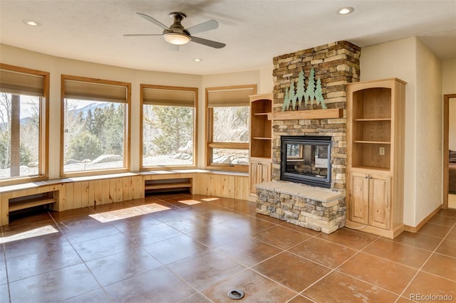 unfurnished living room with a ceiling fan, recessed lighting, a fireplace, and dark tile patterned floors