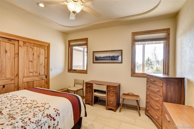 bedroom with ceiling fan, multiple windows, and baseboards