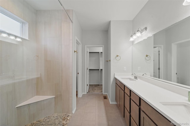 bathroom with tile patterned floors, vanity, and a shower