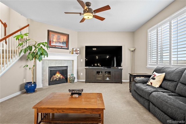 living room with carpet floors, stairway, and a tile fireplace