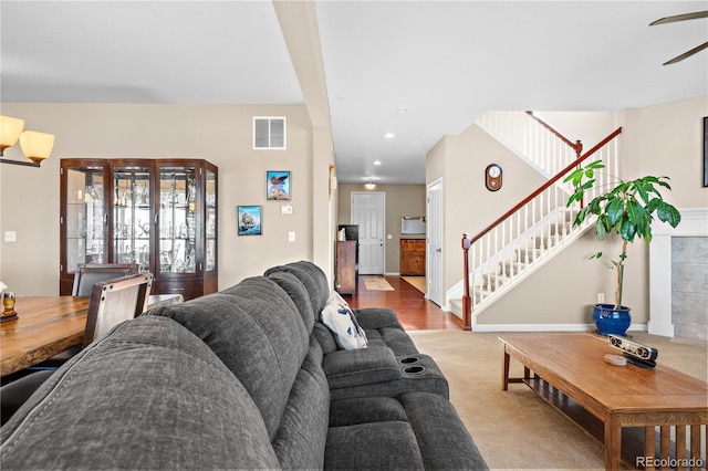 carpeted living room with recessed lighting, visible vents, and stairs