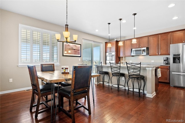 dining area featuring a healthy amount of sunlight, dark wood finished floors, and baseboards