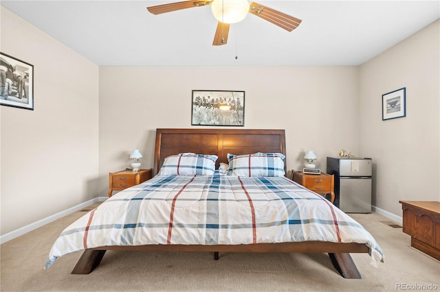 carpeted bedroom featuring freestanding refrigerator, ceiling fan, and baseboards