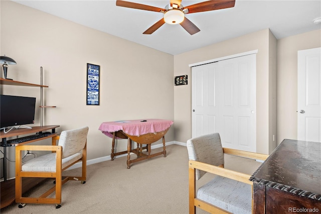 office area featuring a ceiling fan, light carpet, and baseboards