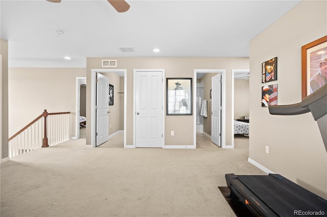 workout room with a ceiling fan, light carpet, visible vents, and baseboards