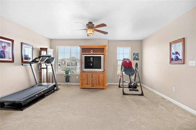 workout room featuring baseboards, a ceiling fan, and light colored carpet